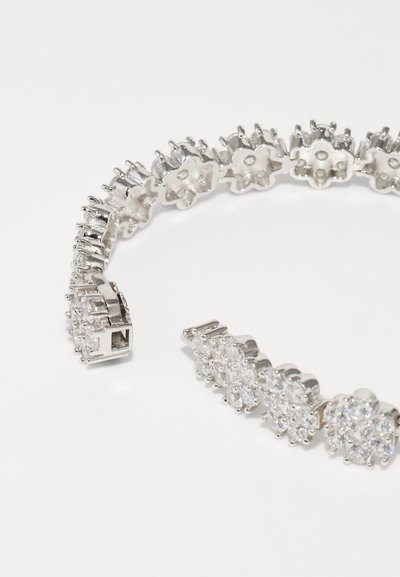 Bracciale in argento con elementi a forma di fiore e tondi alternati, impreziosito da strass trasparenti, creando un design scintillante e texturizzato.