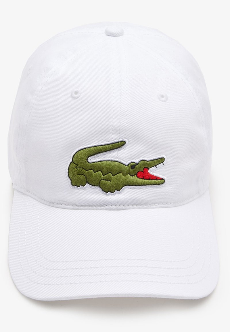 Gorra de béisbol blanca con un logotipo de cocodrilo verde bordado en la parte frontal. El material parece ser algodón con una textura suave.