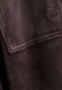 Brown, soft fabric with a smooth texture and a subtle sheen. Includes an embossed letter detail and a neatly stitched border.