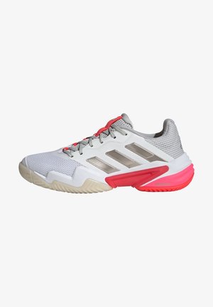 Weißer Sportschuh mit Obermaterial aus Mesh, silbernen Akzenten, rotem Fersenbereich und Sohle. Verfügt über eine strukturierte Außensohle für besseren Halt und einen gepolsterten Schaft für zusätzlichen Komfort.