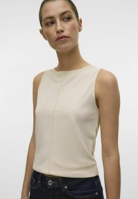 Beżowy top bez rękawów z okrągłym dekoltem, posiadający subtelny pionowy szew z przodu oraz gładką strukturę materiału.