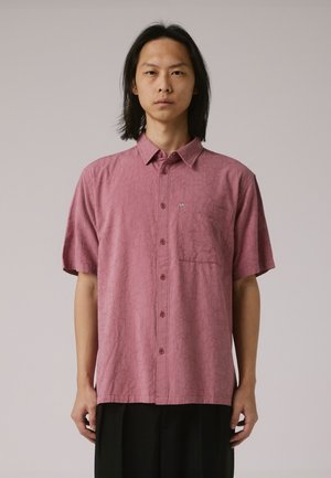 Short-sleeve, button-up shirt in muted pink with a textured pattern. Features a chest pocket and a small logo on the left.