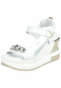 Sandali wedge bianchi con cinturino regolabile, caratterizzati da tre grandi gemme finte sul davanti, materiale liscio simile alla pelle e suola imbottita.