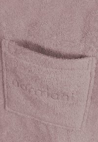 Rosa Frottee-Stoff mit einer genähten Tasche. Die Textur ist weich und saugfähig, mit einem gestickten "armani"-Logo auf der Tasche.