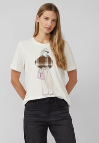 White cotton t-shirt featuring a graphic of a figure in a brown plaid sweater and light-colored pants, holding a pink handbag.