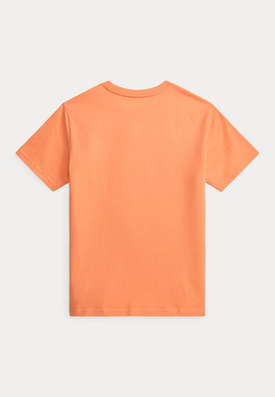 T-shirt uni à manches courtes de couleur pêche unie, présenté à plat avec le dos vers le haut, sur fond neutre.
