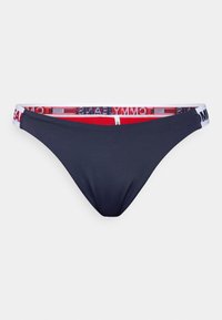 Slip bikini navy con cintura larga bianca e marchio "TOMMY HILFIGER" in rosso e blu. Texture liscia, design a copertura minima.
