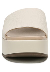 Open-toe platform slide sandal in light beige textured material, with a smooth footbed, subtle platform height, and a low, contoured heel.