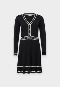 Robe noire tricotée à manches longues, décolleté en V, accents de boutons dorés et ceinture avec logo blanc. Présente une texture côtelée et des finitions contrastantes.