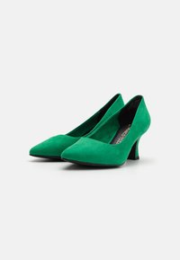 Tacchi alti in suede verde con punta affusolata e design del tacco curvo, caratterizzati da una trama liscia e una silhouette elegante.