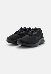 Scarpe sportive nere con tomaia in mesh testurizzato, lacci neri e suola ammortizzata. Presentano un logo discreto sul lato e un collare imbottito.
