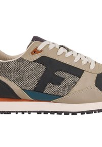 Chaussure de sport légère avec une tige tissée beige, des accents bleu marine, des lacets blancs, une semelle texturée et un logo en relief sur le côté.