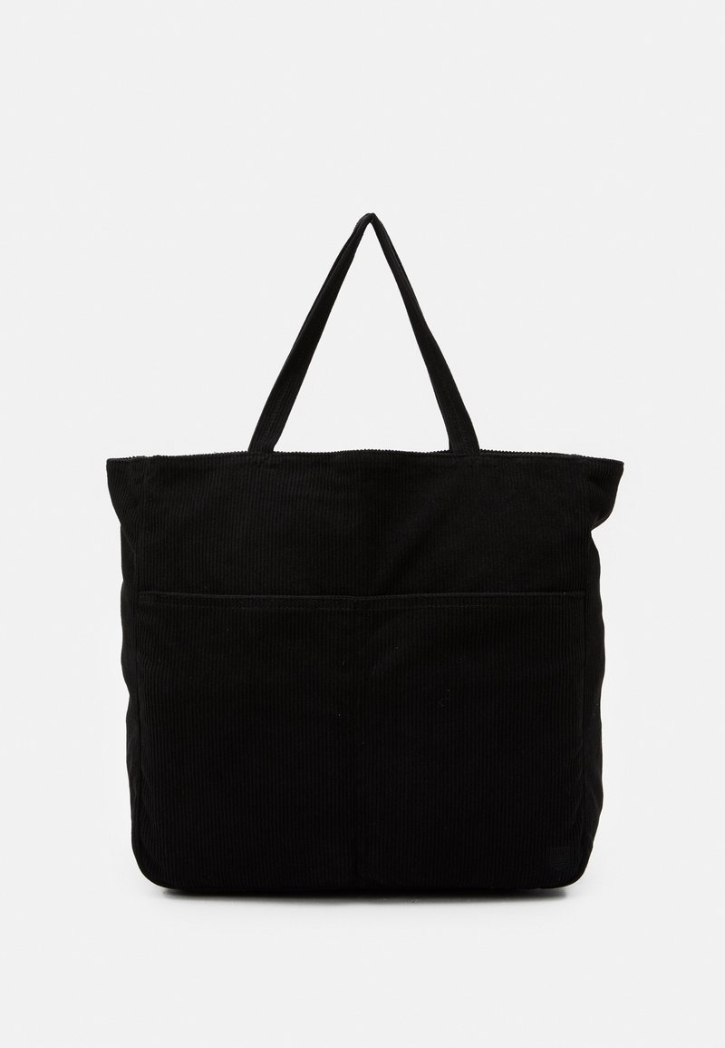 Sac en velours côtelé noir avec deux poignées courtes, arborant un design cousu et une poche avant pour le rangement.