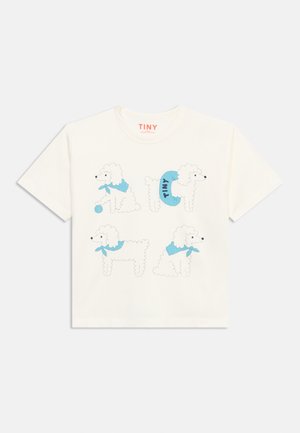 Bílé tričko s krátkým rukávem se čtyřmi kreslenými bílými pudly, kteří mají modré šátky, jeden drží míč, a jeden má modrý obojek s nápisem „TINY“.