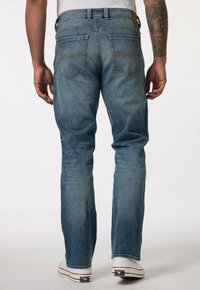 Vaqueros de mezclilla azul con corte recto, lavado claro y costuras en contraste. Cuenta con dos bolsillos traseros con costuras decorativas.