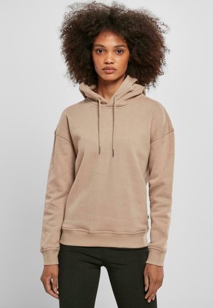 Beige hettegenser laget av mykt materiale, med foret hette, snorene og ribbestrikkede mansjetter. Enkel design med en avslappet passform.