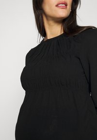 Černý dlouhý rukáv top s nařasením kolem výstřihu a poprsí, vyrobený z měkké texturované látky a s volně padnoucím střihem.