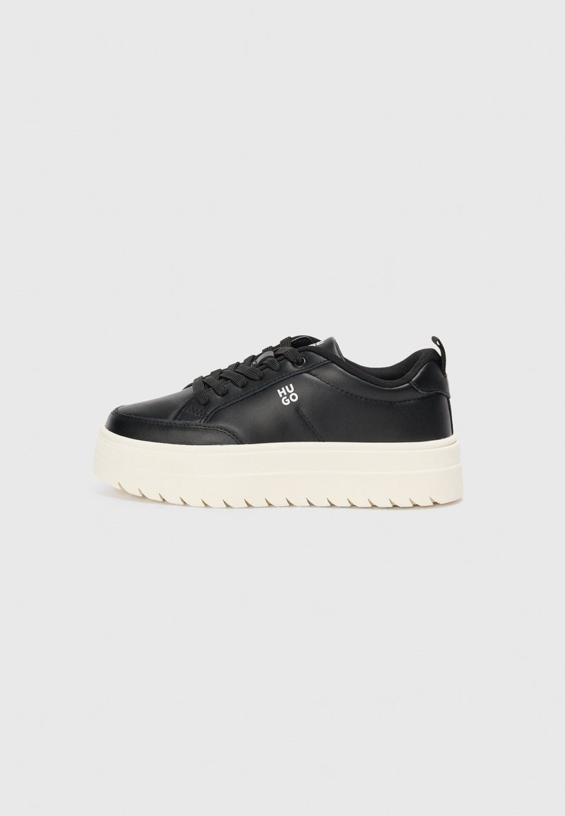 Baskets basses noires avec semelle plateforme blanche, lacets et logo « HUGO » sur le côté, vues de profil gauche sur fond gris.
