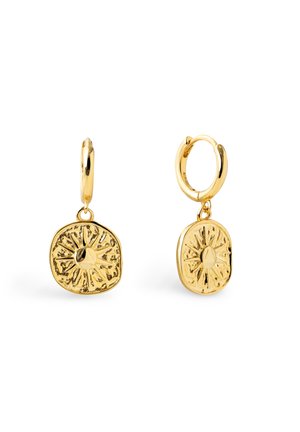 Boucles d'oreilles créoles en or avec des pendentifs ronds texturés en forme d'éclat de soleil suspendus à chaque créole sur fond blanc.