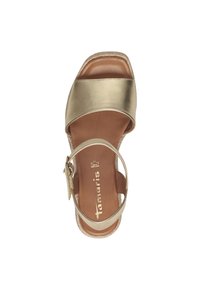 Gold metallic sandal with wide straps, a closed toe, and an adjustable ankle strap. Cushioned insole and woven edge detail. Smooth texture.