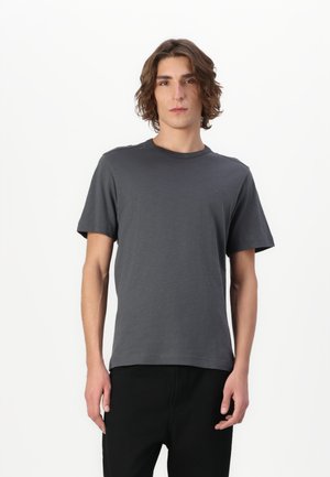 Dunkelgraues kurzärmliges T-Shirt aus weichem Stoff, mit Rundhalsausschnitt und einem subtilen Logodetail auf der Brust. Minimales Design.