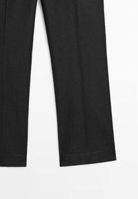 Schwarze gerade geschnittene Hose mit einfachem Saum, flach liegend auf weißem Hintergrund dargestellt.