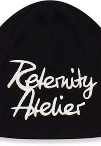 Gorra de punto negra con texto bordado en blanco "Rele and Atelier." Presenta una corona redondeada y textura acanalada. No hay detalles adicionales visibles.