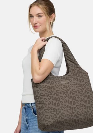 Große braune Tragetasche mit Leopardmuster, weicher Textur und breitem Schulterriemen, gehalten von einer Person in weißem Hemd.