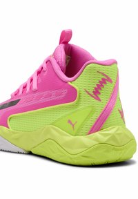 Chaussures de sport roses et vert néon avec une tige en mesh, une finition texturée et une semelle géométrique distincte. Elles présentent le logo Puma et une languette de tirage.