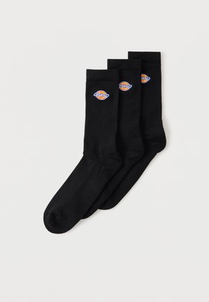 Kolm paari musti meeskonnasokke soonikservadega, igal paaril väike ümmargune mitmevärviline Dickiesi logo peal.