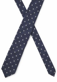 Granatowy krawat z fakturowanym wykończeniem, z małymi białymi wzorami w kwiaty równomiernie rozmieszczonymi na całej powierzchni. Zwężane końce z ostrym czubkiem.
