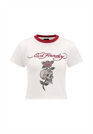 White cotton crop t-shirt with red ribbed crew neckline; features a skull and rose design embellished with colorful rhinestones.