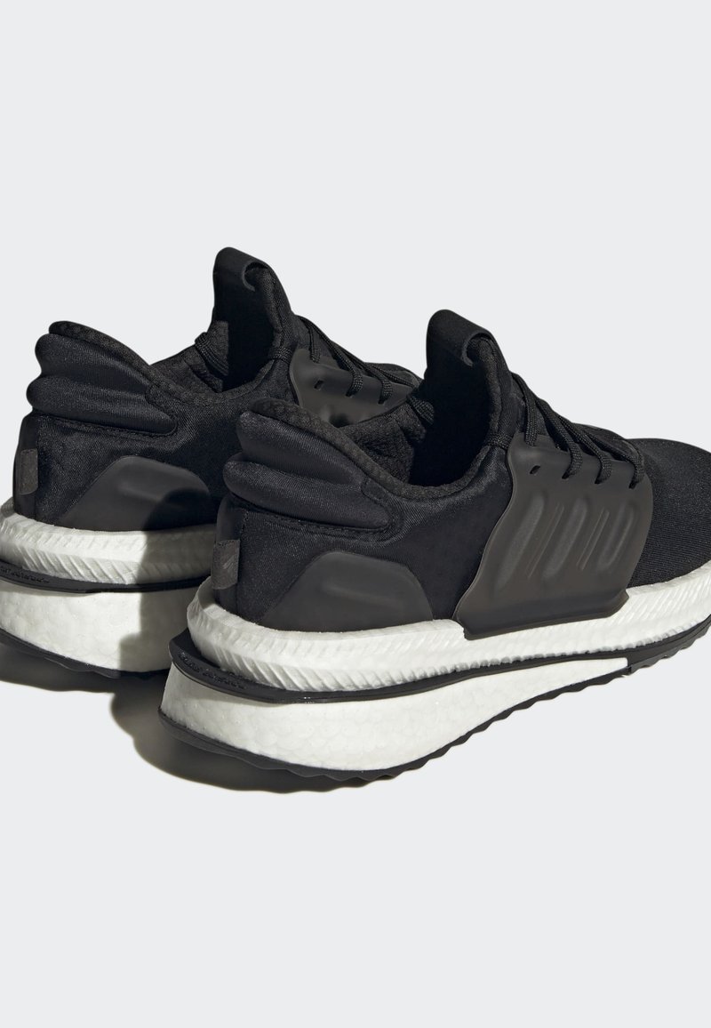 Schwarze Sportschuhe mit strukturiertem Obermaterial, gepolstertem weißen Zwischensohle und Gummisohle. Besitzt einen gepolsterten Kragen und auffällige seitliche Akzente.