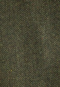 Ull herringbone-tyg med en texturerad yta, som har mörkgröna och olivfärgade nyanser, accentuerat av subtila bruna fläckar i ett zigzag-mönster.