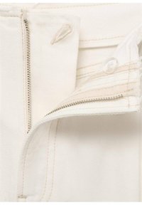 Tessuto denim bianco con zip laterale e chiusura a bottone, caratterizzato da cuciture avorio e dettagli di texture sottili.