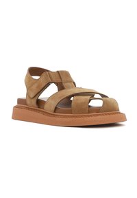 Brown suede sandal with an open design, featuring cross straps, a cushioned footbed, and a thick rubber sole for stability.