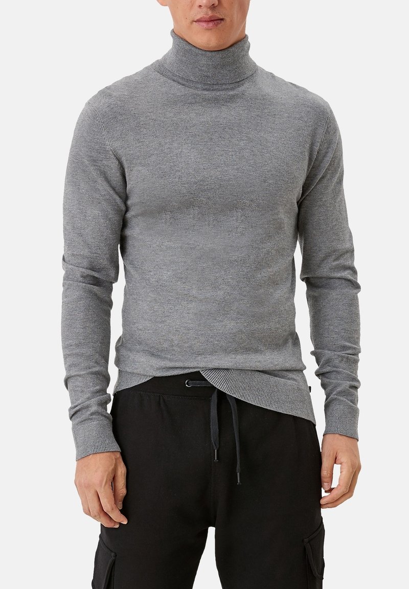 Pull à col roulé gris en tissu doux, coupe ajustée, avec manches longues et col côtelé, associé à un pantalon noir à cordon de serrage.
