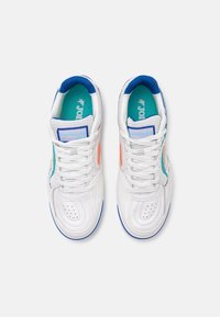 Zapatillas altas blancas con detalles perforados y acentos en azul, naranja y verde azulado. Diseño con cordones y cuello acolchado para mayor comodidad.