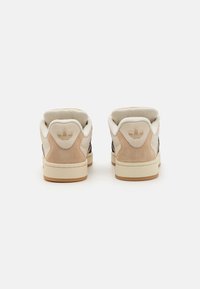 Sneakers en cuir et en daim avec une combinaison de couleurs beige et marine. Équipés d'un collier rembourré, d'une semelle en caoutchouc et d'un logo embossé au niveau du talon.