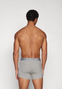 Grå bomull boxershorts med hvite horisontale striper og en myk grå linning, vist fra baksiden, som fremhever linningen og beinåpningene.