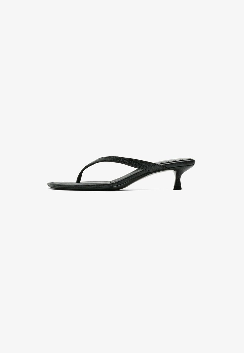 Sandale noire en cuir de type tongs à petit talon kitten et bout carré, vue de profil sur fond blanc.