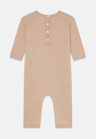 Beige bomull onesie med lange ermer, knappelukking bak og fotløs design. Myk tekstur med glatt finish.
