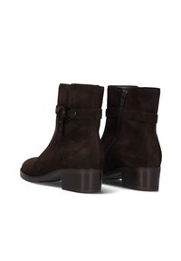 Bottines en daim marron avec un bout rond, un talon bloc de hauteur intermédiaire, une fermeture éclair sur le côté et une sangle décorative avec un détail de boucle.