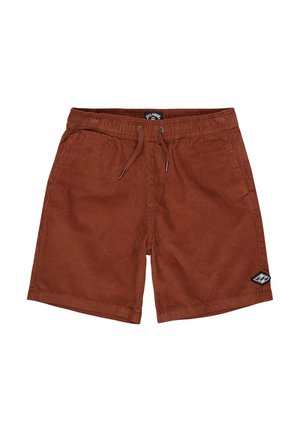 Brązowe sztruksowe szorty o teksturowanym wykończeniu, noszone z czarnymi tenisówkami z białymi sznurowadłami. Na górze kolorowa koszula z wzorem.