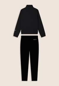 Conjunto de chándal negro que incluye una chaqueta con cremallera y cuello alto, y pantalones a juego. Ambos tienen detalles con el logo "FREDDY". Textura suave.