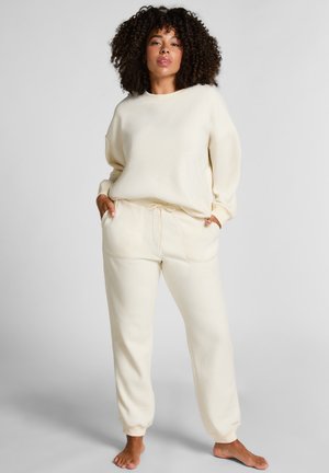 Crème-kleurige loungeset van zachte stof; bevat een relax-fit sweatshirt en tapervormige joggingbroek met een elastische tailleband en trekkoord.