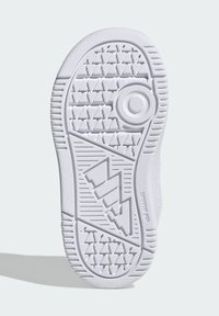 Valge kummist tossu talla tekstuuriga pind. Omab geomeetrilisi mustreid, ringikujulisi aktsente ja sileda serva haarduvuse tagamiseks.