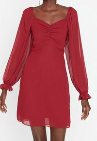 Rotes Chiffonkleid mit quadratischem Ausschnitt, gerafftem Vorderteil und langen Puffärmeln. Verfügt über geraffte Manschetten und eine fließende Silhouette.