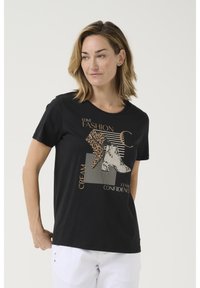 T-shirt noir à manches courtes avec imprimé graphique représentant un léopard et des bottes blanches, texte en or et crème, col rond, tissu doux.