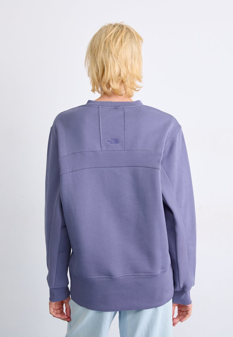 Paarse sweatshirt met een relaxed fit, ronde hals en geribbelde manchetten. Heeft een subtiele merkl logo op de bovenrug. Soepele textuur.